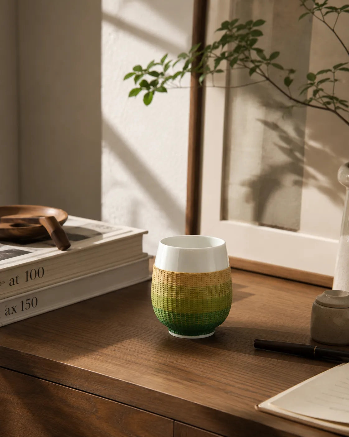 A handwoven bamboo porcelain tea cup placed in a calm study setting, designed for quiet rituals and slow living spaces.