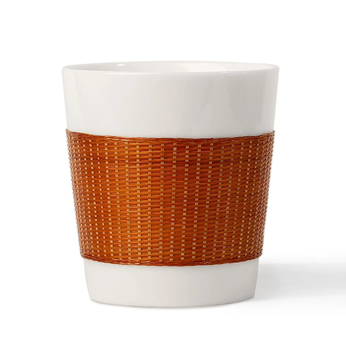 THE YUNXI Daily Cup in Baked, with a dark woven bamboo sleeve over white porcelain.