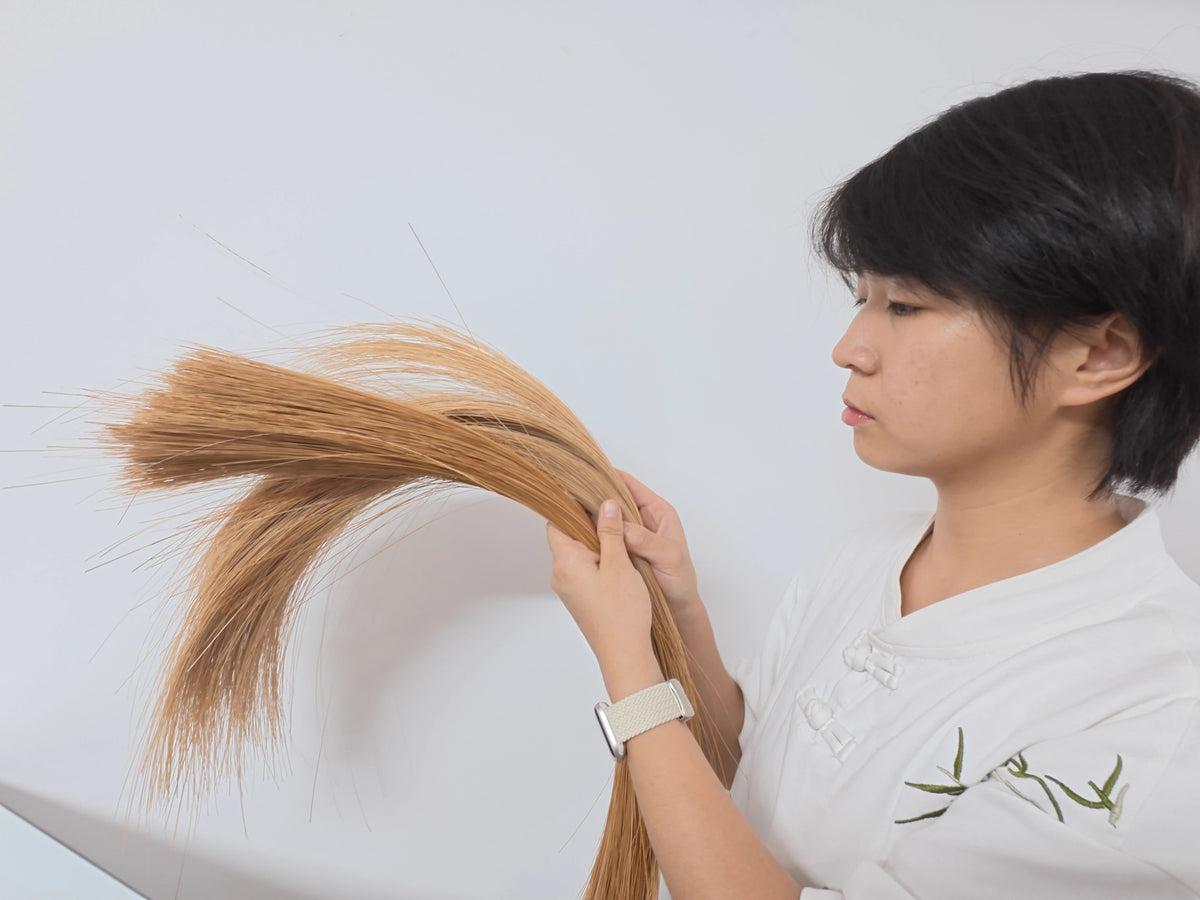 Liu Luolin inspecting prepared bamboo filaments by hand