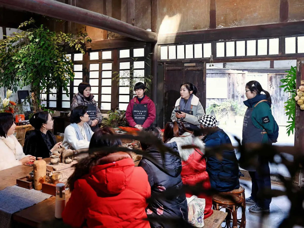 A group gathered around tables during a discussion at Hualin Banghu Culture and Art Studio.